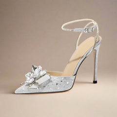 Silver high-heeled shoe with decorative flower on a white background