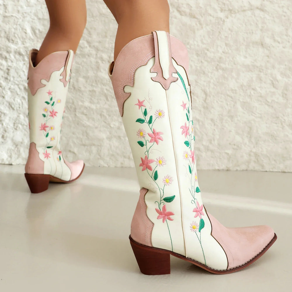 Pink and white cowboy boots with floral designs on a light background