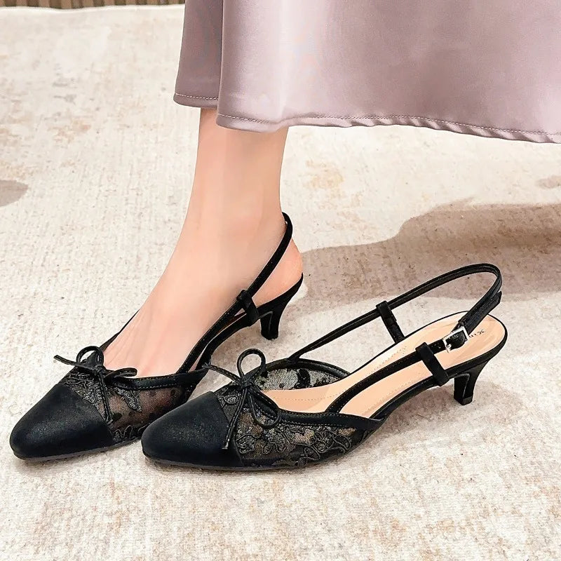 Black lace slingback kitten heel pumps styled on feet