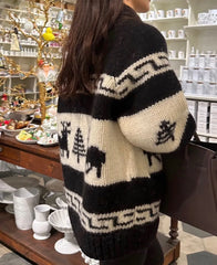 Person wearing a black and white patterned cardigan in a store setting