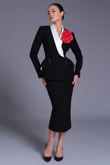 Full body view of black peplum blazer with contrast lapel and flower brooch
