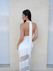 Woman wearing a white saree with a subtle pattern against a light background