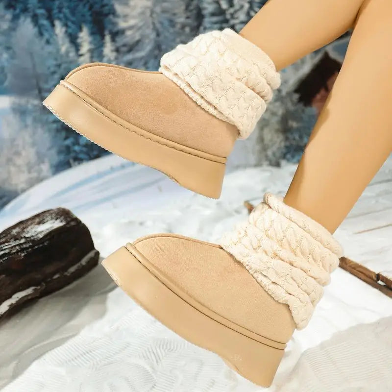 Tan winter boots with white fur trim worn by a person in a snowy landscape.