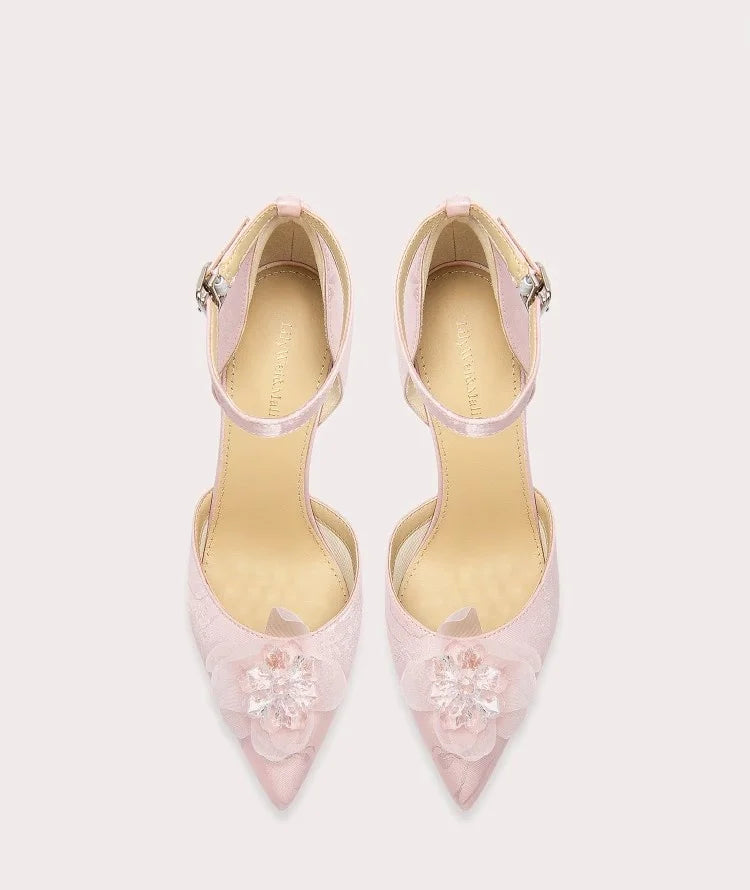 Pair of pink high-heeled shoes with floral details on a white background