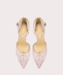 Pair of pink high-heeled shoes with floral details on a white background