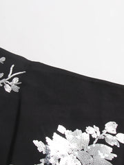 Black fabric with white floral embroidery on a light gray background