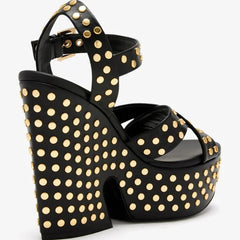 Side view of a black leather platform wedge sandal adorned with gold studs
