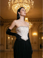 Woman in an elegant evening gown with a chandelier in the background