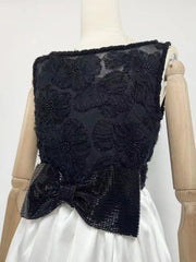 Black beaded vest with a bow on a mannequin against a white background