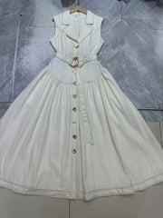 Light-colored dress with buttons on a textured gray background