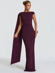 Woman wearing a burgundy jumpsuit with a cape on a white background