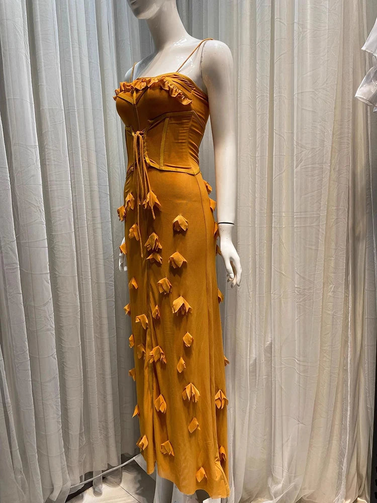 Mustard yellow dress with floral details on a mannequin against a white curtain background
