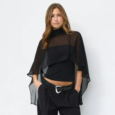 Sheer cape overlay high neck top worn by a model