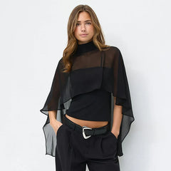 Sheer cape overlay high neck top worn by a model