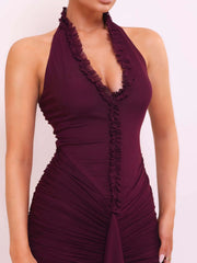 Maroon halter neck dress with ruffled details on a plain background