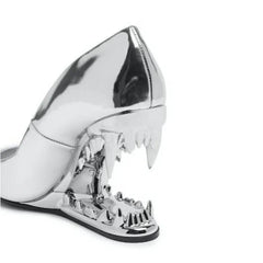 Silver high-heeled shoe with unique design on a white background