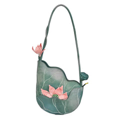 Green handbag with pink floral designs on a white background