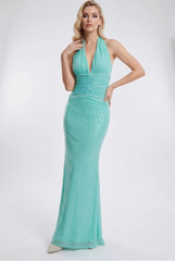 Woman wearing a teal evening gown in a studio setting