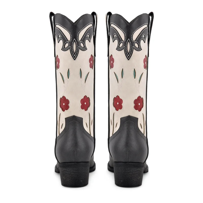 Black and white cowboy boots with red floral patterns on a white background