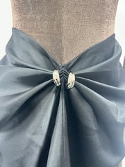 Mannequin wearing a light blue fabric bow with decorative elements on a neutral background