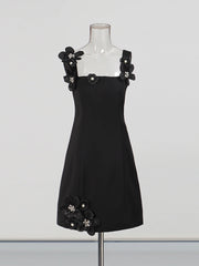 Black dress with floral embellishments on a mannequin against a white background