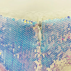 Sequined fabric with a zipper running through it, on a light background.