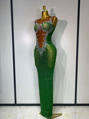 Green evening gown with beaded details on a mannequin against a white wall.