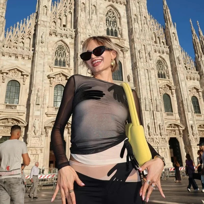 Woman posing in front of a cathedral with a yellow bag