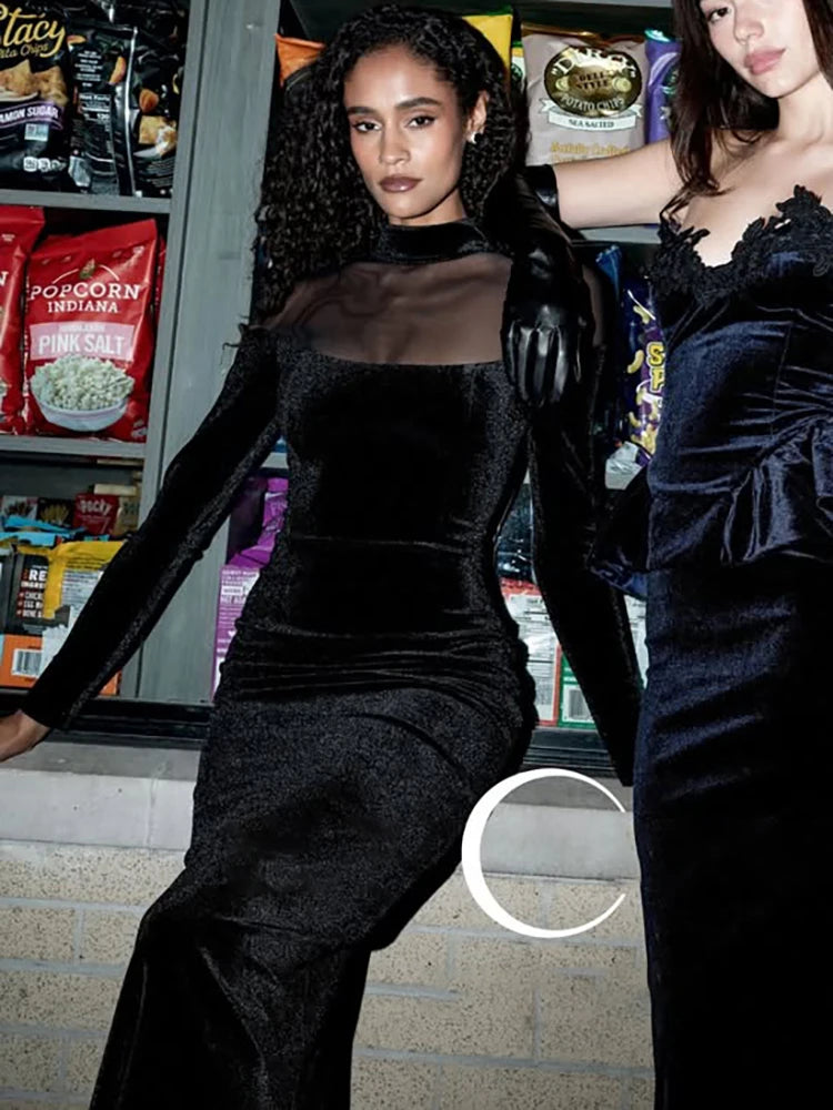 Two women in black dresses standing in front of a store with snacks on the shelves.