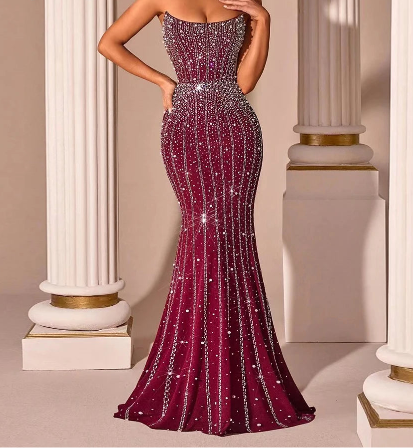 Elegant burgundy evening gown with sparkling details against classical columns.