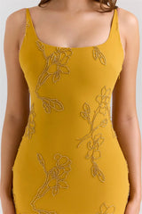 Yellow dress with floral bead embroidery on a plain background