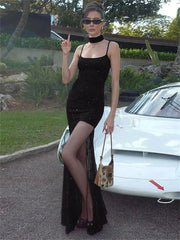 Woman in a black dress standing next to a white car outdoors
