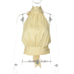 Yellow halter top on a mannequin against a white background