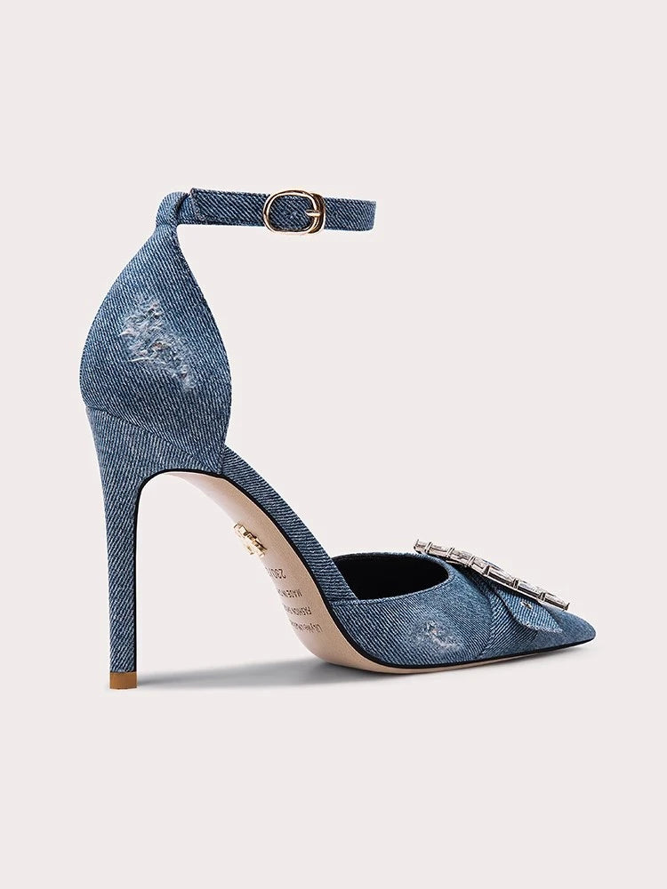 Blue denim high-heeled shoe with a strap on a light gray background