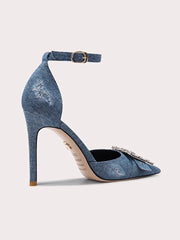 Blue denim high-heeled shoe with a strap on a light gray background