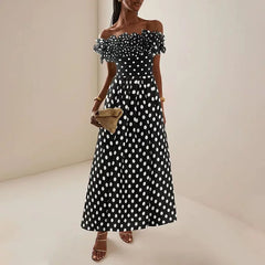 Woman wearing an off-the-shoulder ruffled polka dot swimsuit and matching maxi skirt.
