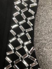 Close-up of a black shoe with silver embellishments on a textured gray surface