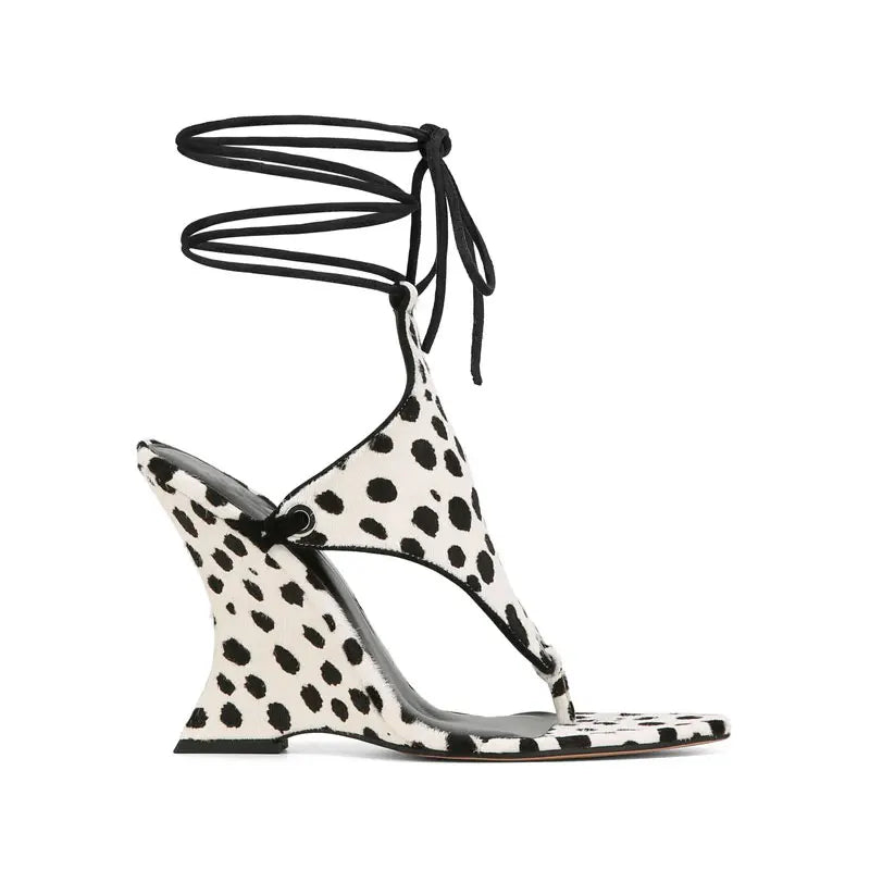 Side view of a dalmatian print lace-up wedge sandal