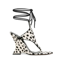 Side view of a dalmatian print lace-up wedge sandal