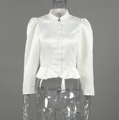 White blouse on a mannequin against a gray background