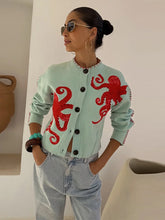Model wearing an octopus jacquard knit cardigan outdoors