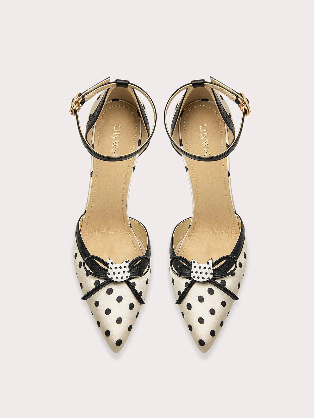 Pair of polka dot high heels with bow details on a white background