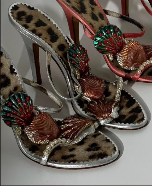 Close-up of seashell embellished stiletto heel sandals in silver and leopard print
