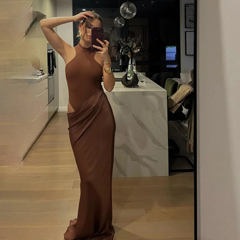Person wearing a brown dress taking a mirror selfie in a room.