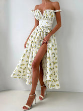 Woman wearing a floral off-shoulder dress with a high slit on a plain background