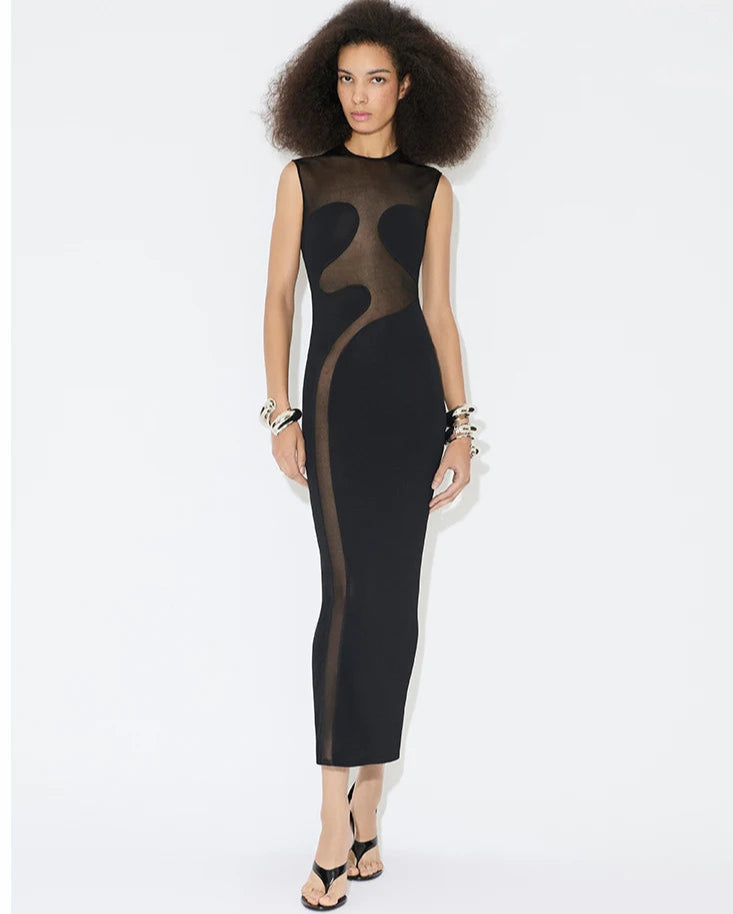 Woman wearing black mesh panel dress against a white background