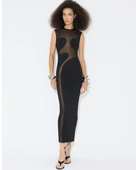 Woman wearing black mesh panel dress against a white background