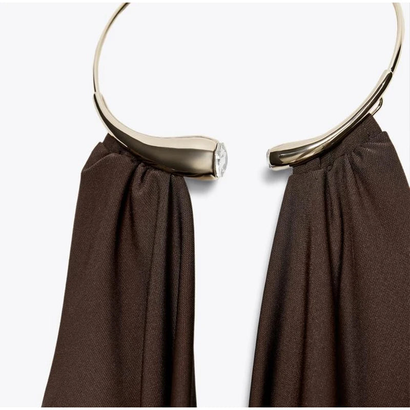 Gold hoop earring on a brown fabric background