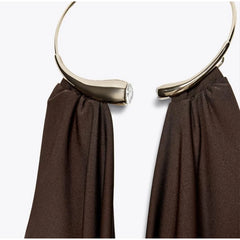 Gold hoop earring on a brown fabric background