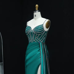 Teal evening gown with silver embellishments on a mannequin against a black background